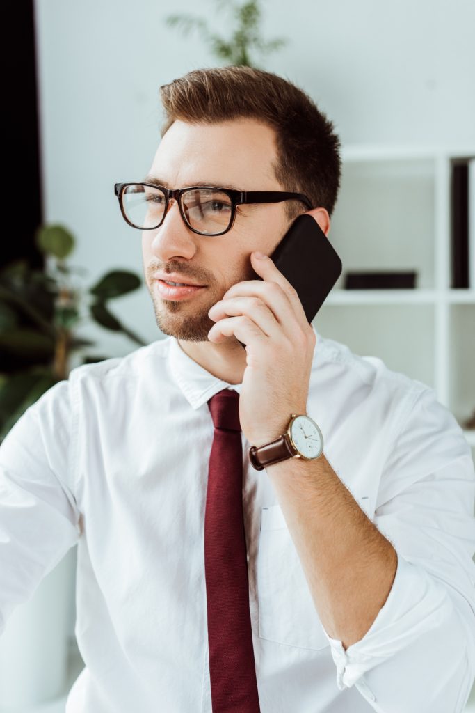 handsome businessman talking on smartphone while working in office